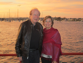 Two people pose for photo with ocean backdrop